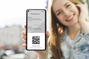 Eine Patientin zeigt ihr Smartphone, auf dem ein E-Rezept samt QR-Code zu sehen ist.